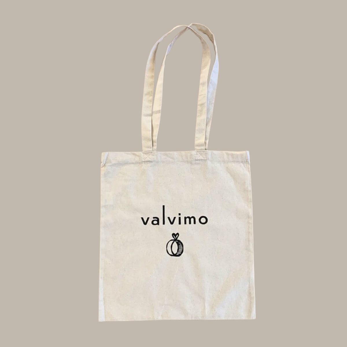 Luonnonvalkoinen kangaskassi pitkillä kantohihnoilla ja Valvimo-logolla.
